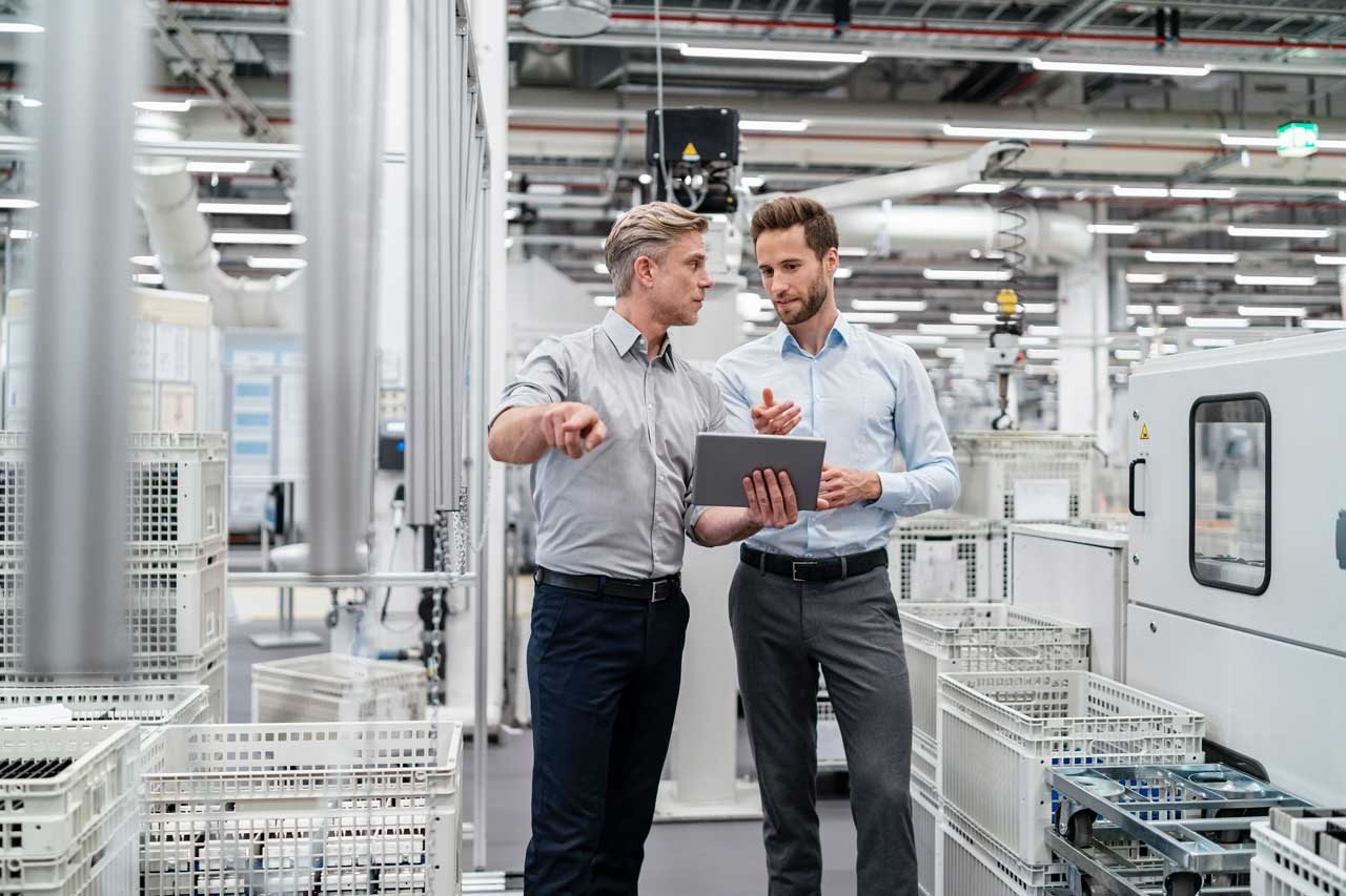 two-businessmen-with-tablet-talking-in-a-modern-facility